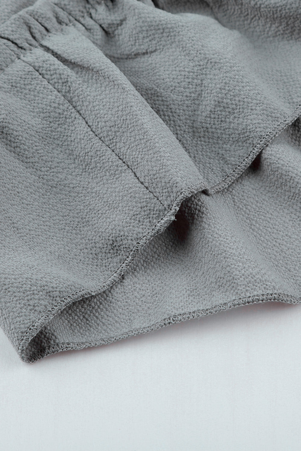 Graues Minikleid mit V-Ausschnitt und langen Ärmeln und Rüschen