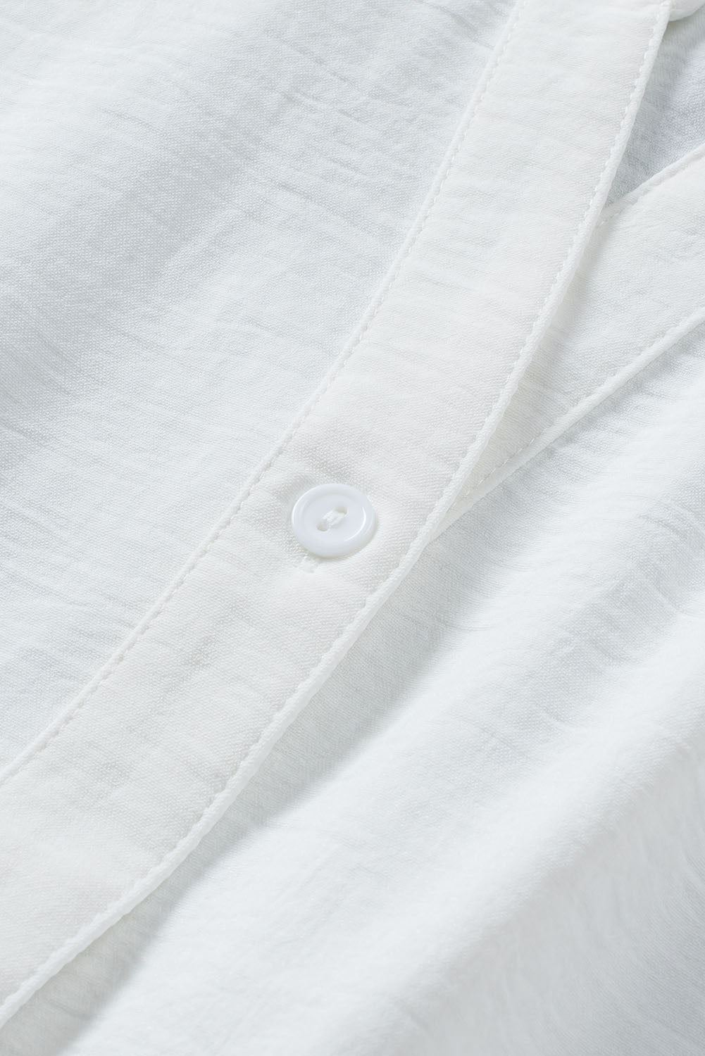 Chemise blanche sans manches à col fendu et cordon de serrage à la taille
