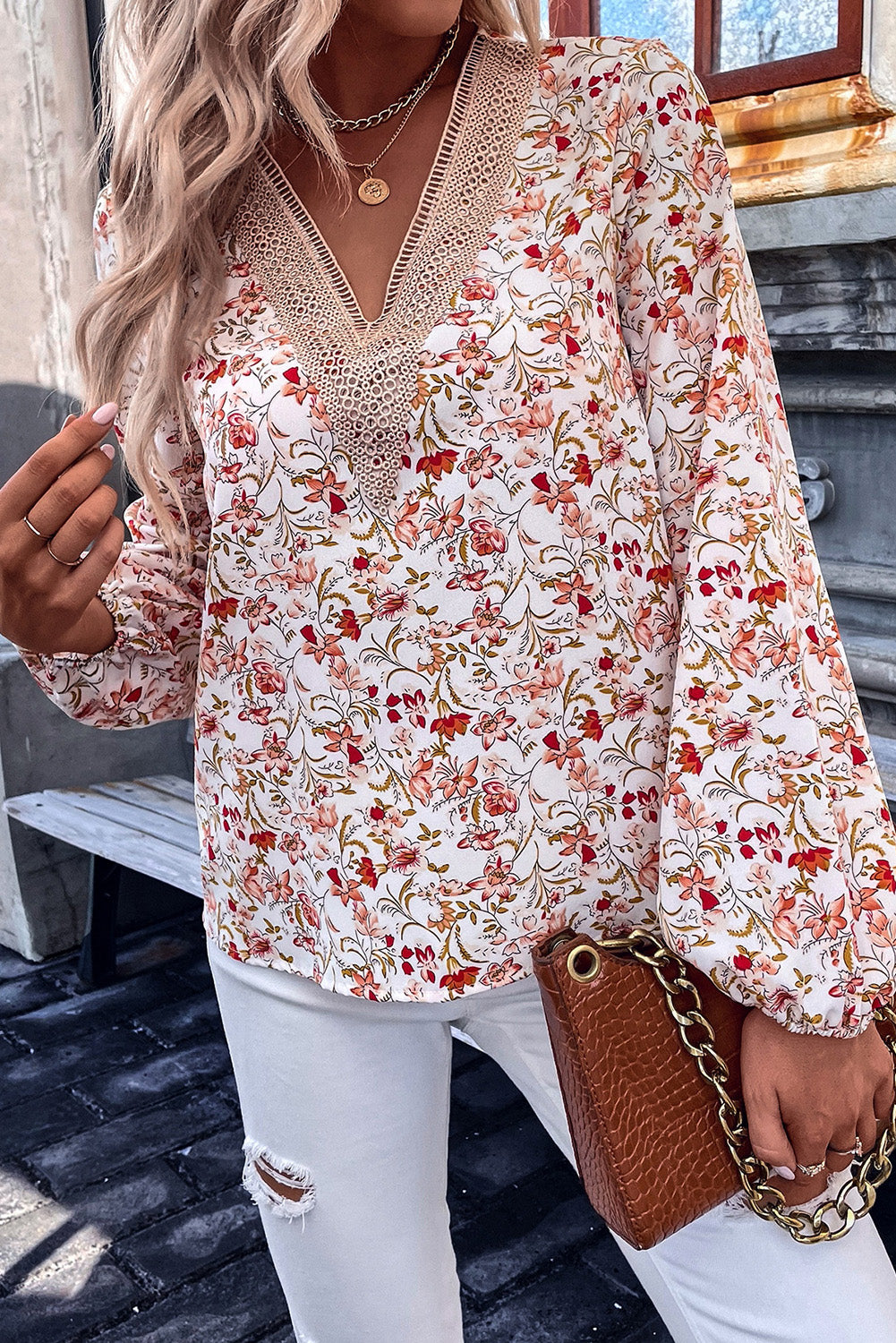 Bela bluza s čipkastim v-izrezom in dolgimi rokavi s cvetličnim motivom