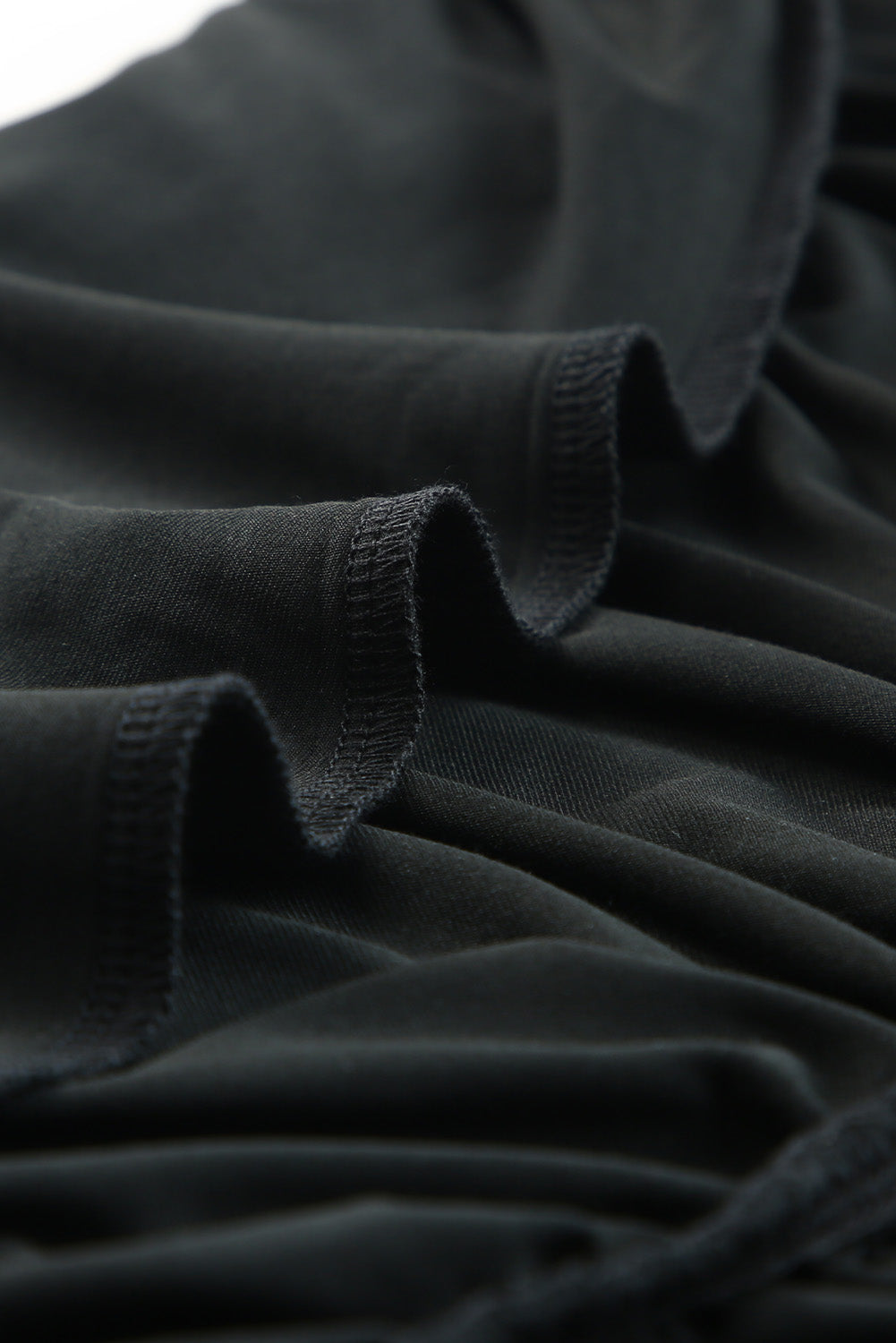 Crna haljina kratkih rukava s naborima na jedno rame uz donji dio